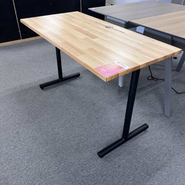 desk with maple top, 1 round cord hole, black T legs on either side, side view