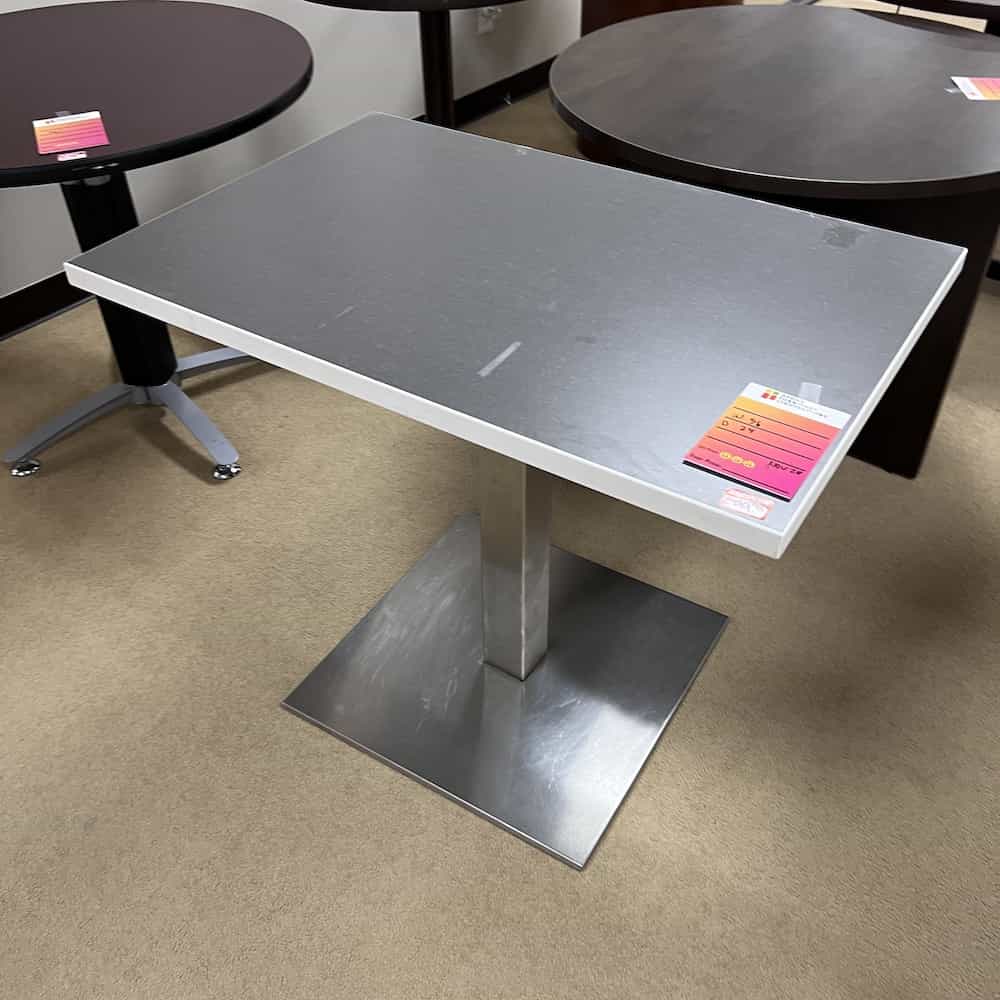 grey laminate top, white edging, silver metal base with rectangle floor stabilizer