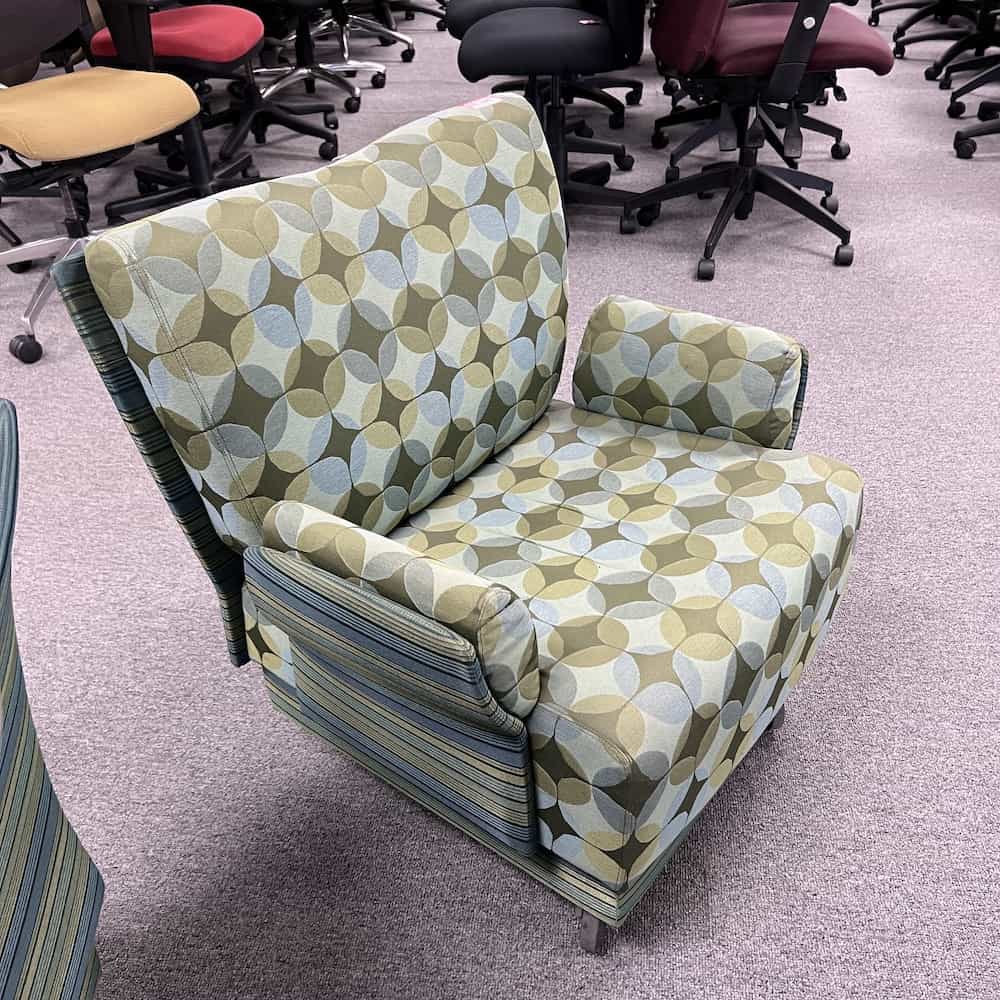 green upholstered chair with two patterns: stripes and diamond/circles. arm on both sides, front view