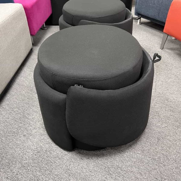 black ottoman that has a back rest that flips up and down depending on use - pictured down