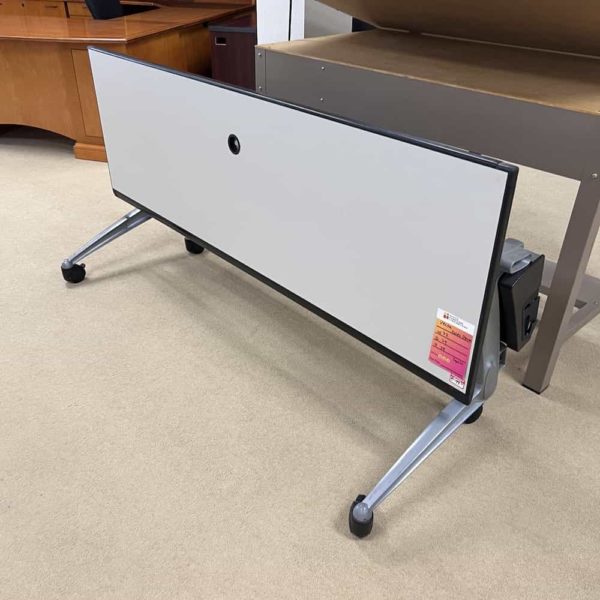 training table with white laminate top with black edges, silver legs and wheels flipped down