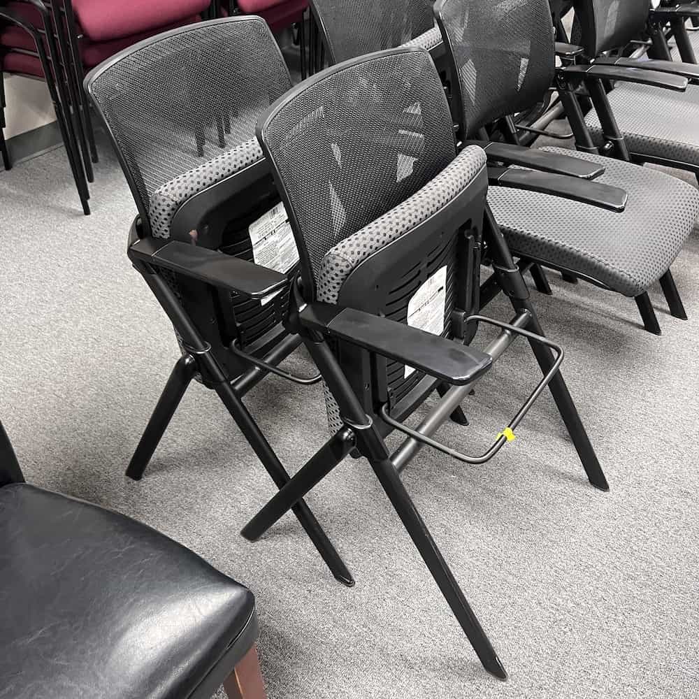 grey and black kimball flip chair, upholstered seat, mesh back, seat flipped up