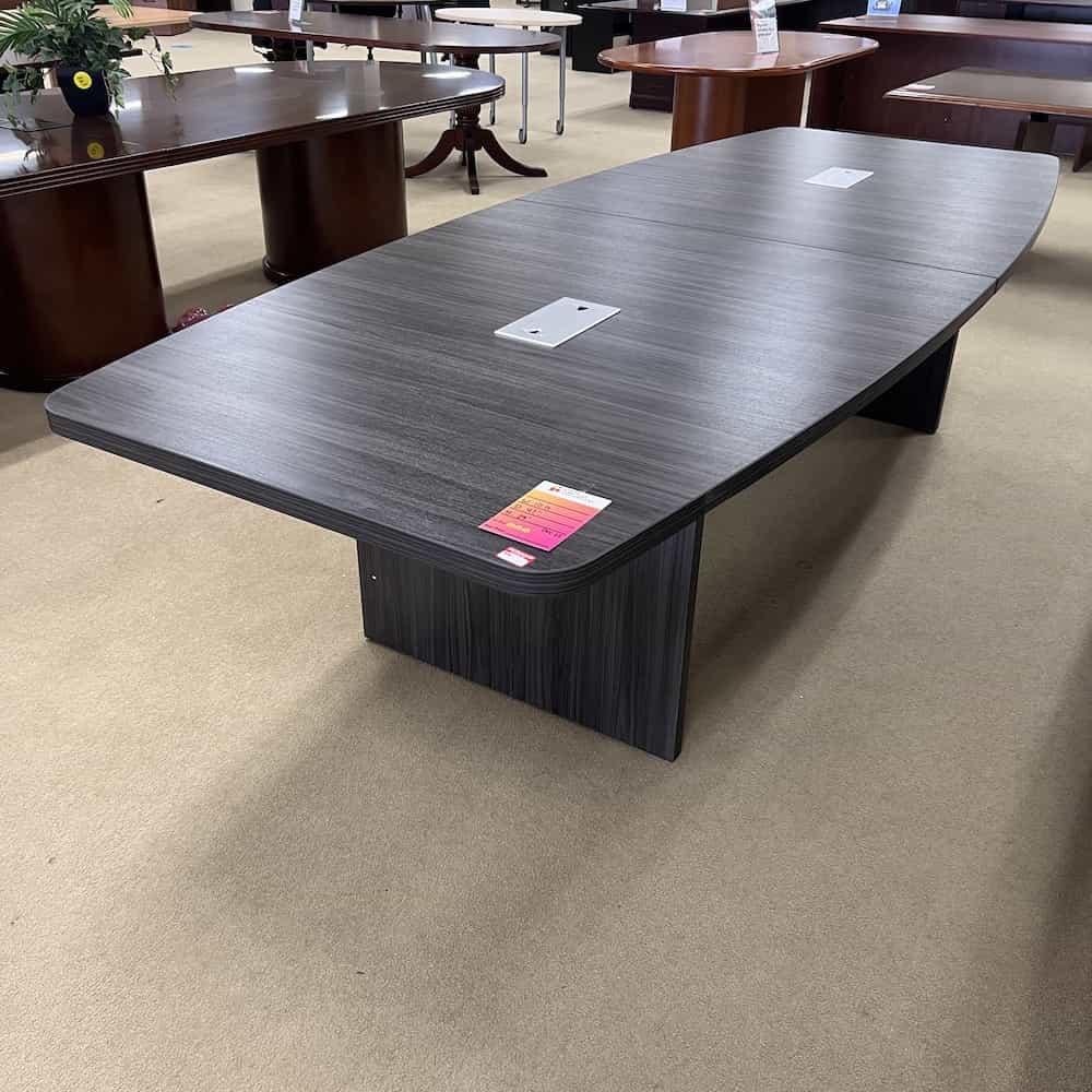 grey boat shaped conference table with 2 cord ports