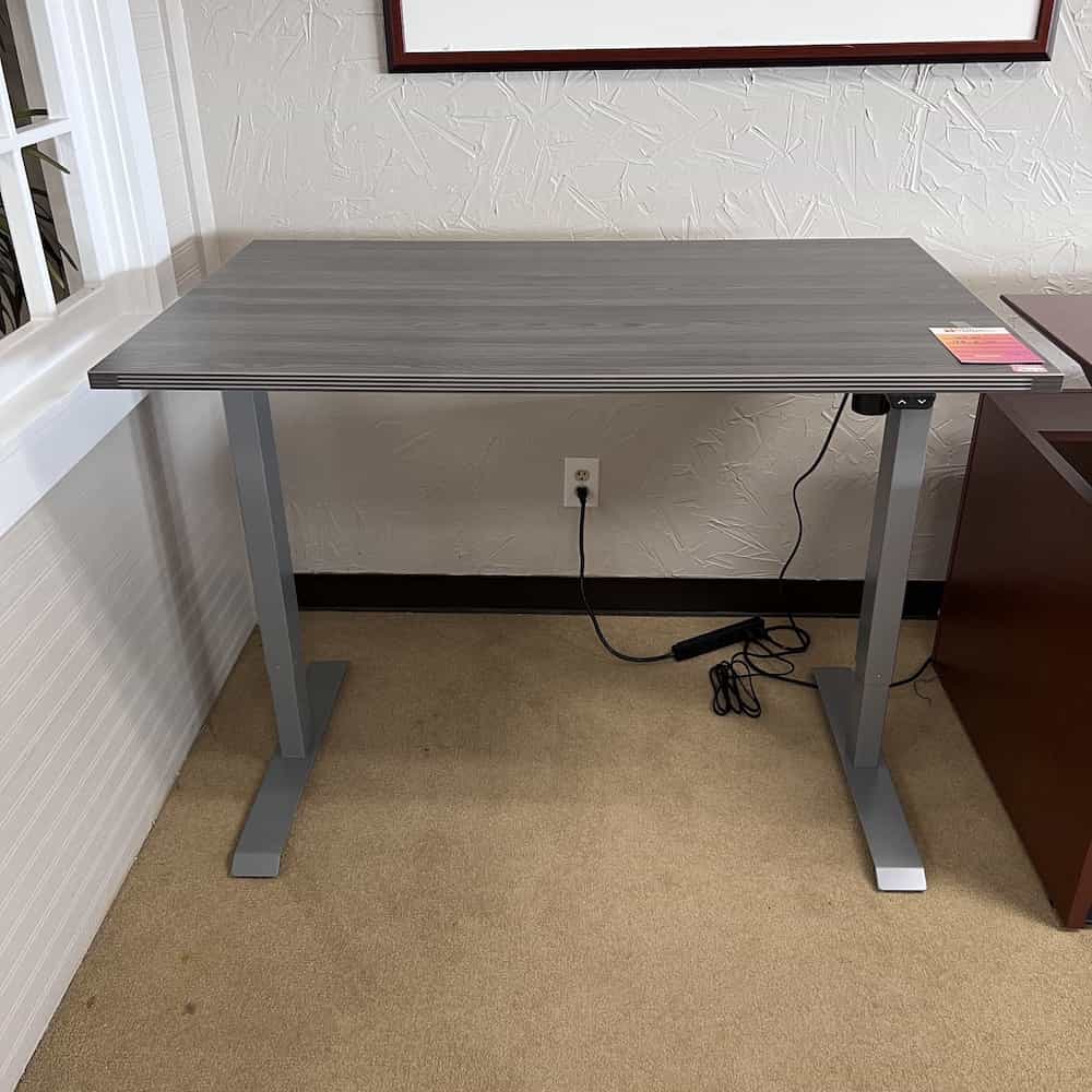grey laminate desk with silver legs, black controller for up down