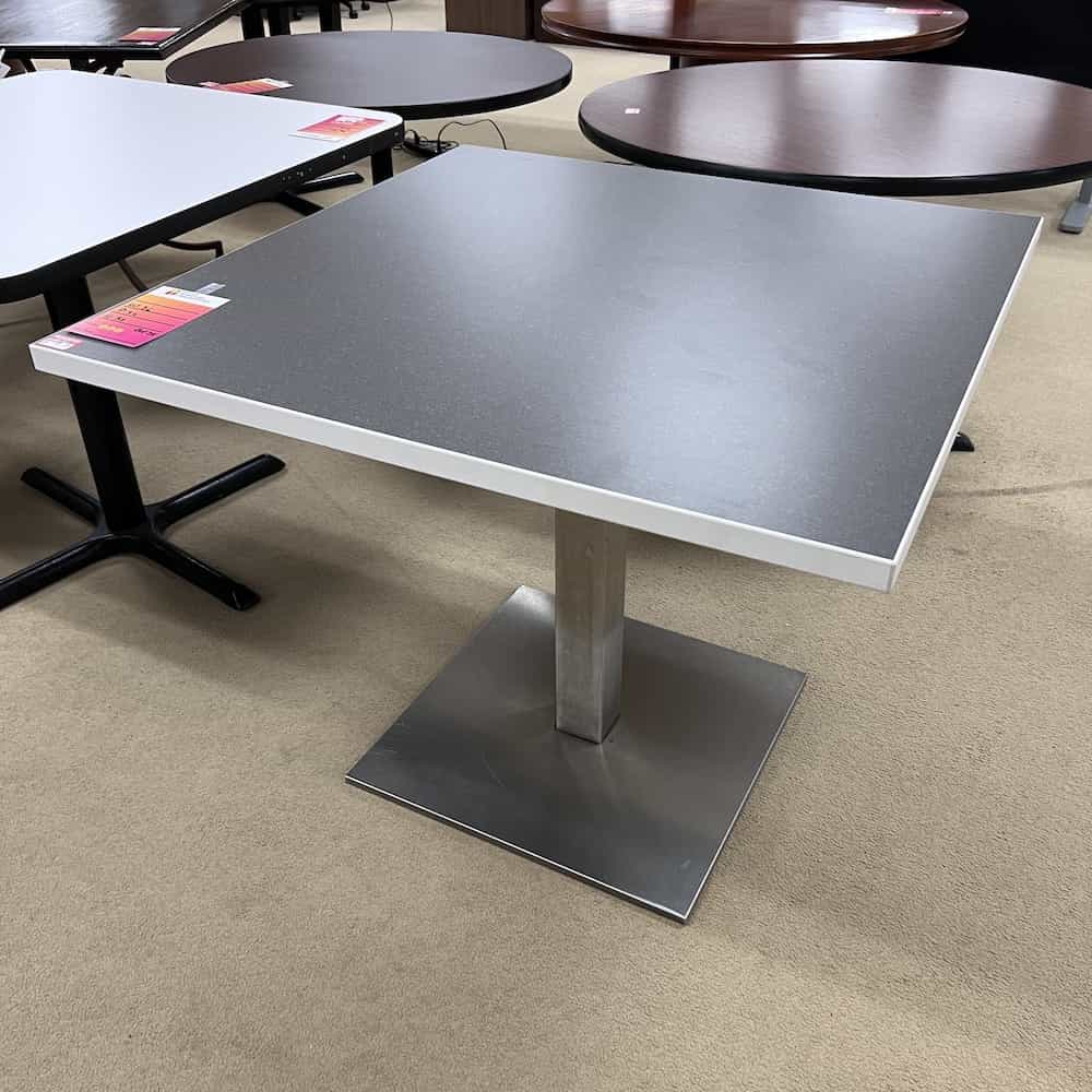 grey laminate top, white edging, silver metal base with square floor stabilizer
