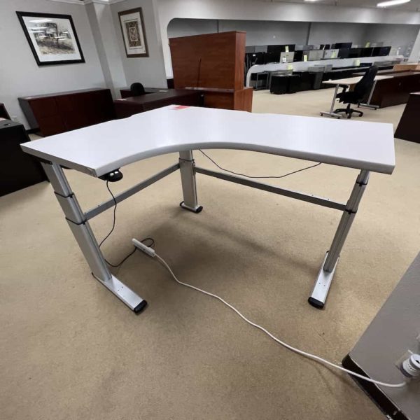 light grey mechanical l-desk, standing, height adjust