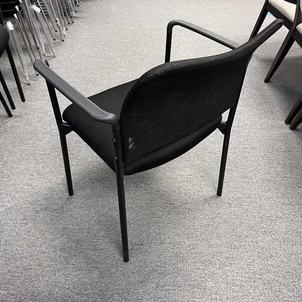 black mesh back stacking chair with arm rests