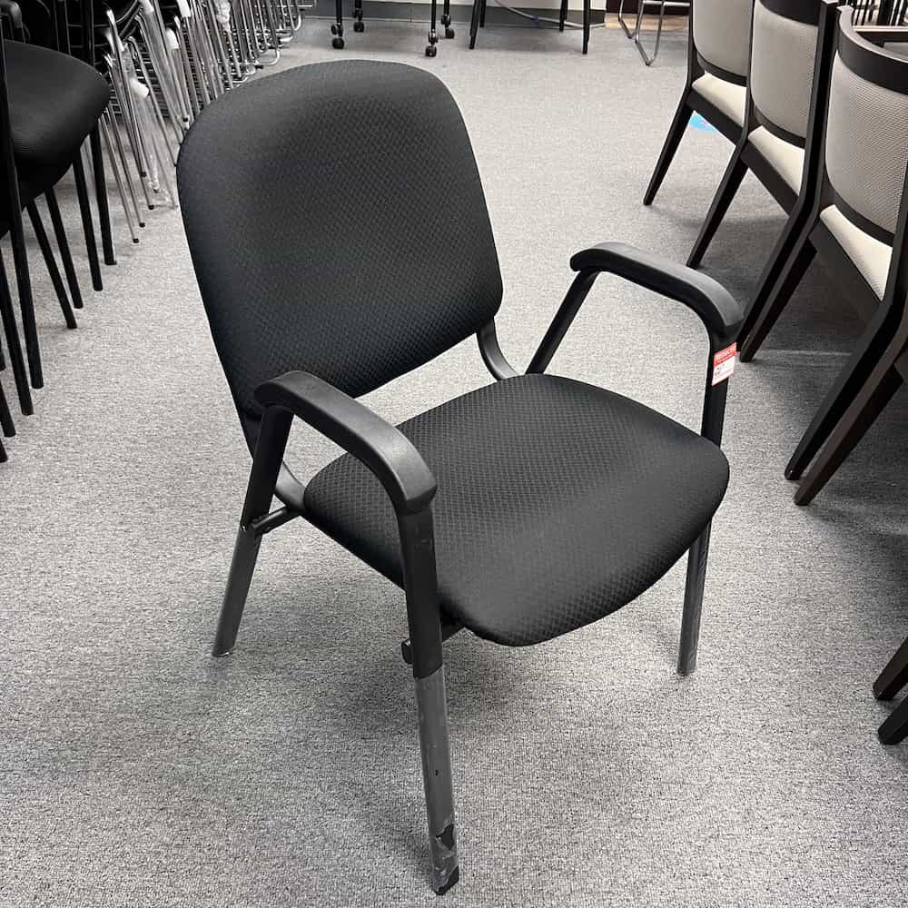 black upholstered stacking chair with arm rests