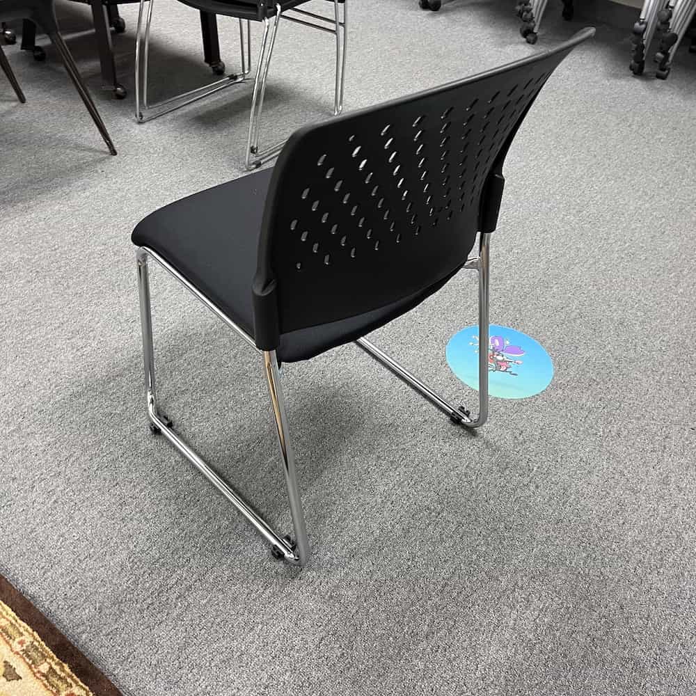 black plastic stacking chair with upholstered seat
