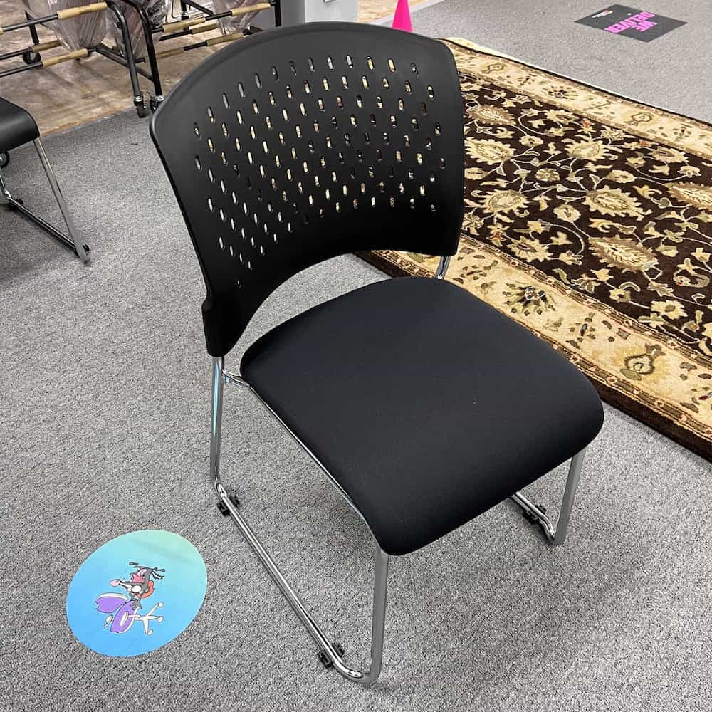 black plastic stacking chair with upholstered seat