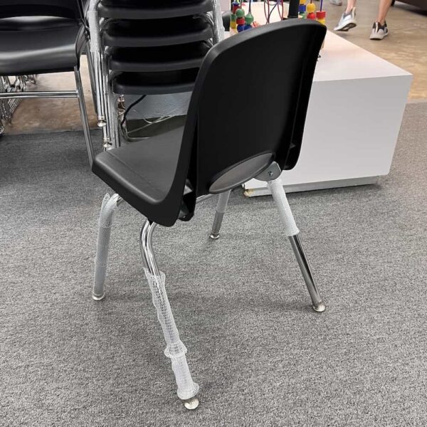 black plastic student seat stacking with chrome legs and circle opening in back