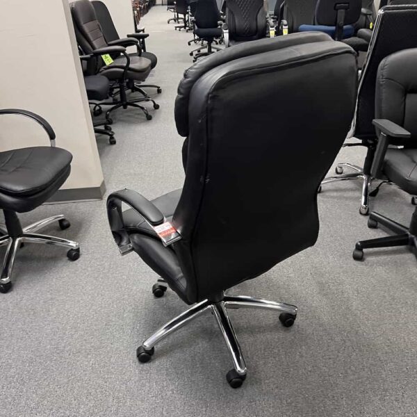 damaged black and chrome bomber chair, back view