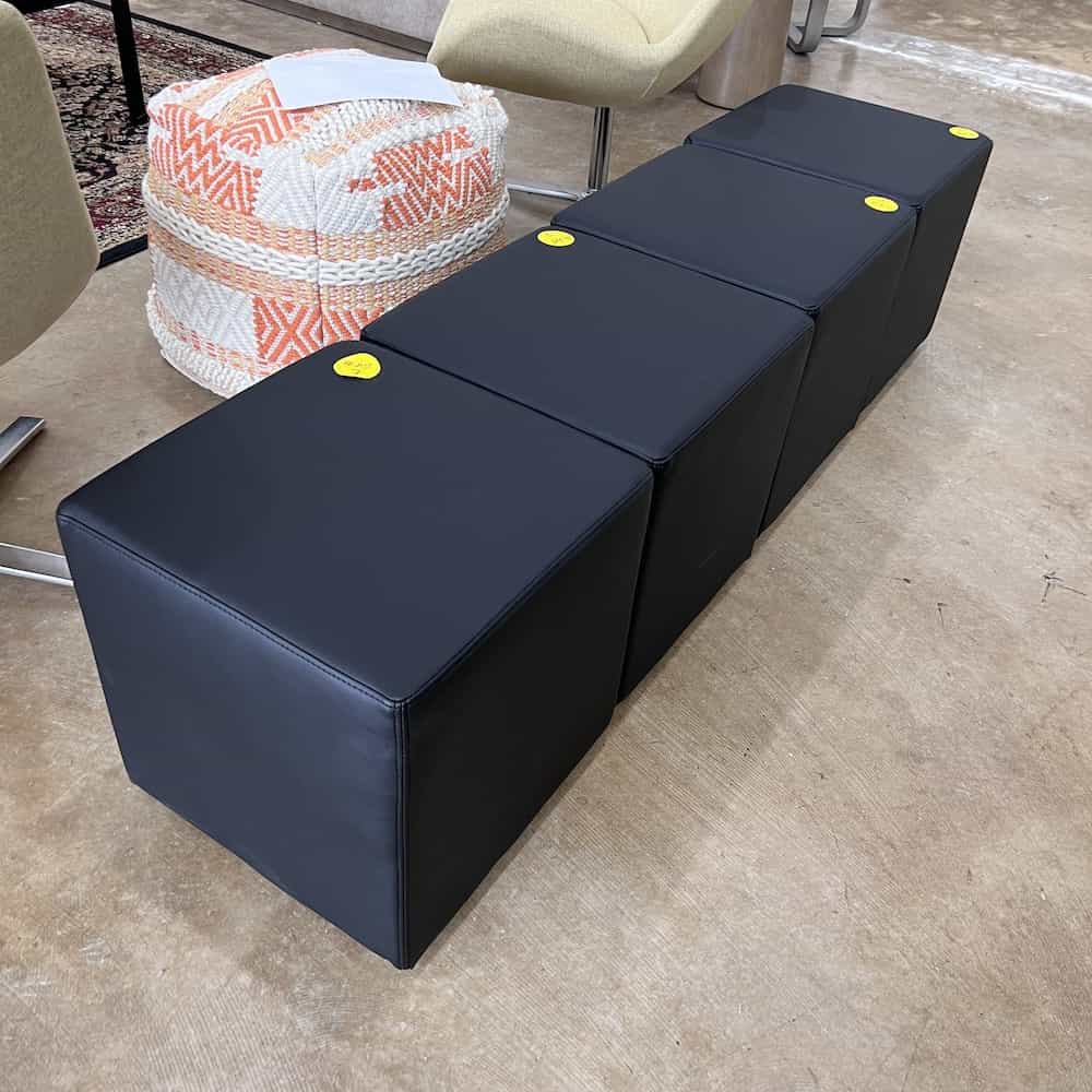 black vinyl square ottomans, in a row like a bench