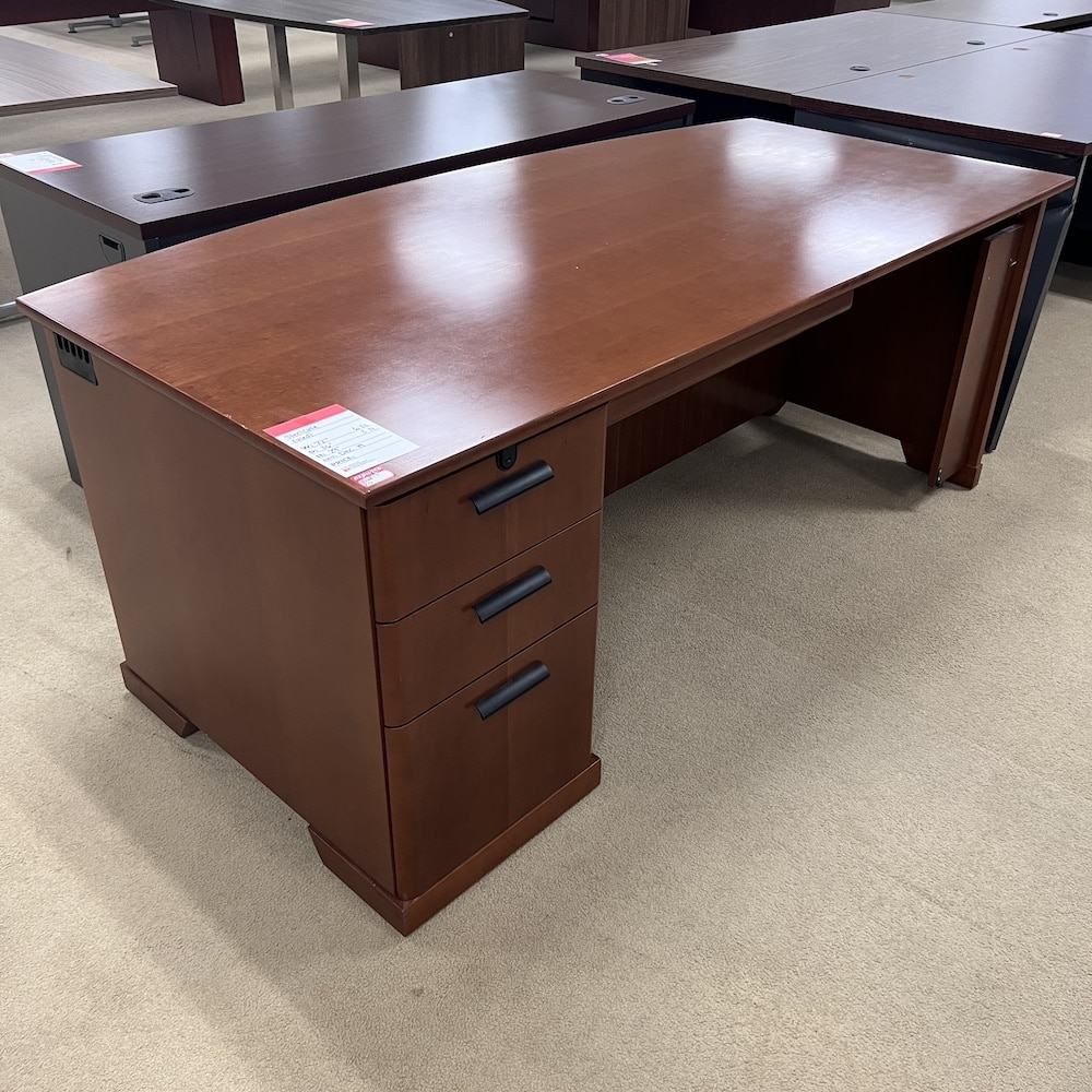 cherry veneer desk with bow front, one pedestal on the left side, black pulls