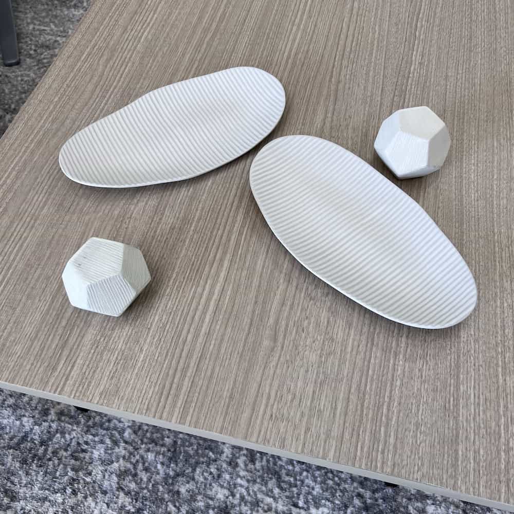 white decor, ceramic oval plates with lines texture, and geometric shapes