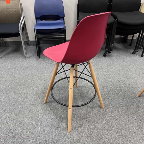 red bucket chair with maple legs and black stabilizers, back