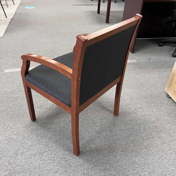 black upholstered guest chair with cherry veneer frame, back view