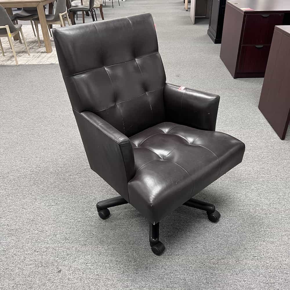 dark brown leather conference chair with arms and a light tufted look, front view