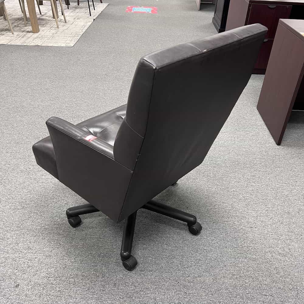 dark brown leather conference chair with arms and a light tufted look, back view