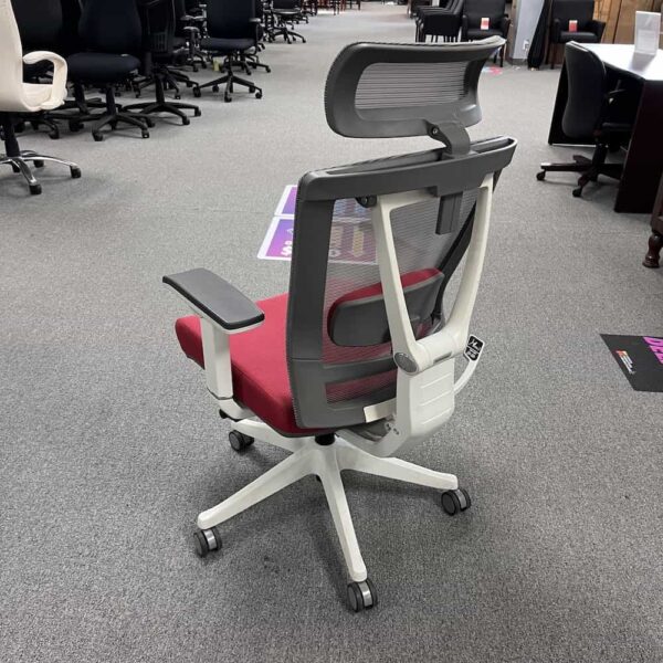 red autonomous ergonomic chair with grey mesh back and a headrest, back view