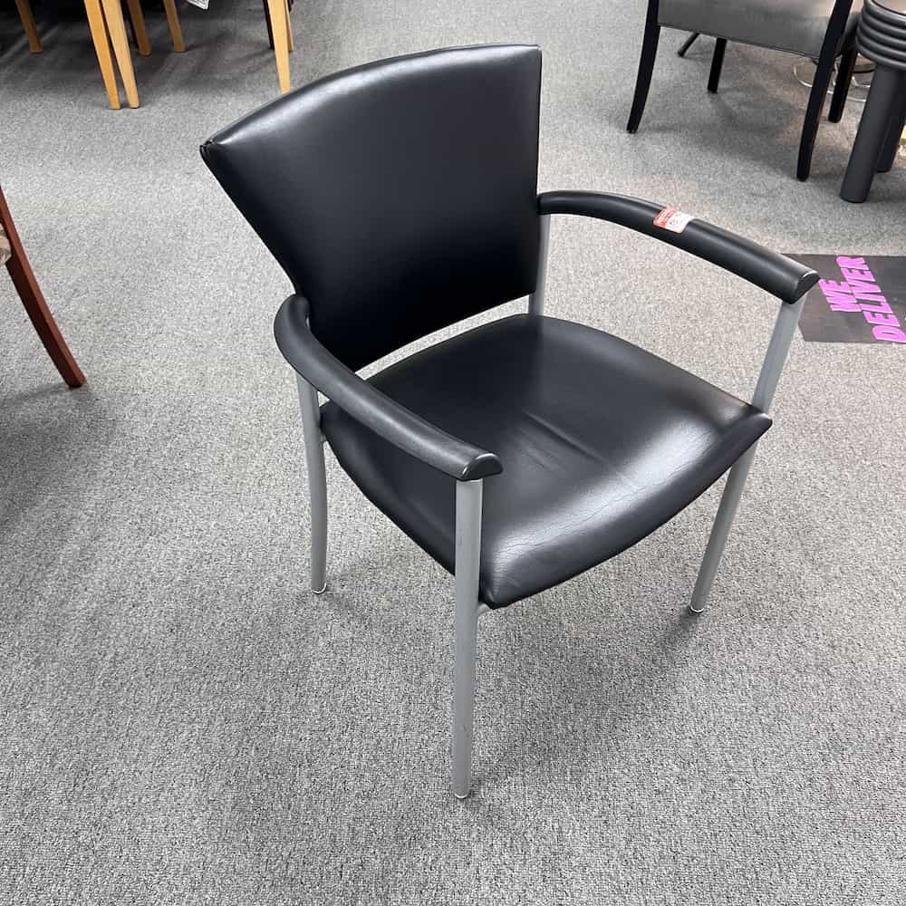 black vinyl guest chair with grey silver arms, black plastic arm pads
