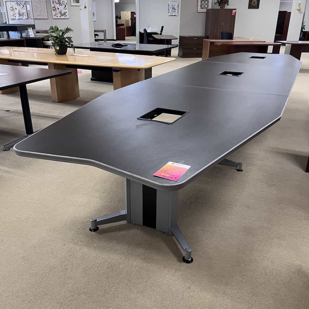 18 ft laminate conference table in a angular long shape, silver legs and edging, 3 square chord holes