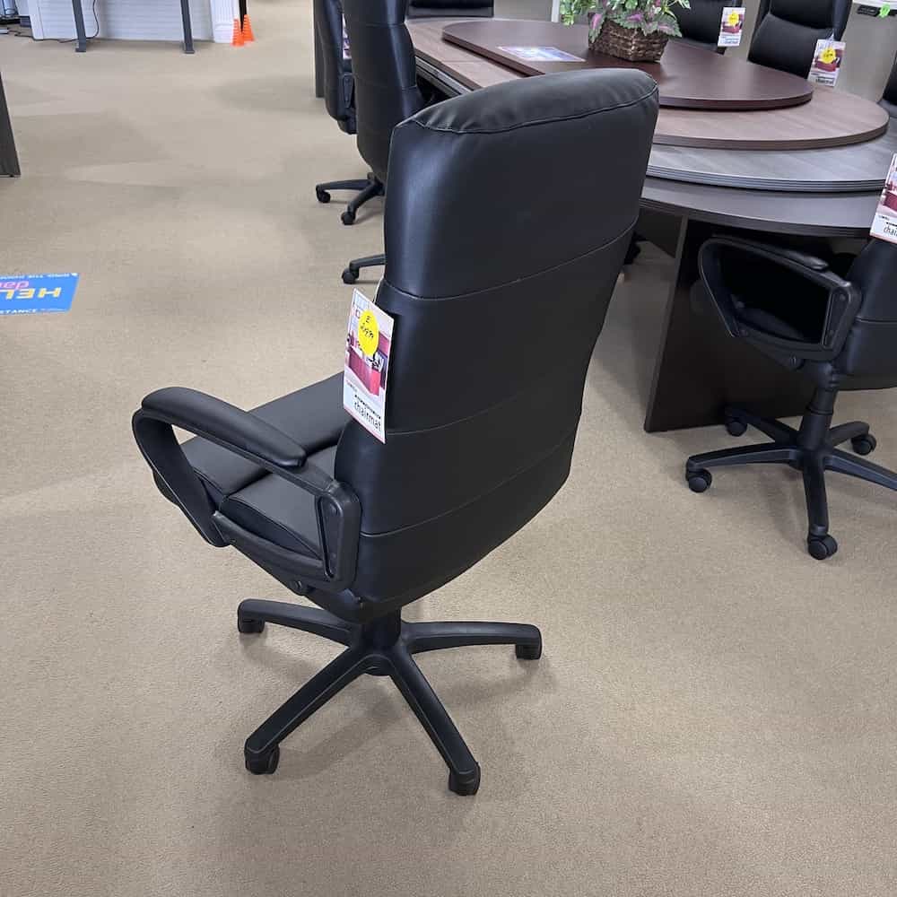 new plush conference chair in black vinyl with fixed arms and high back, back view