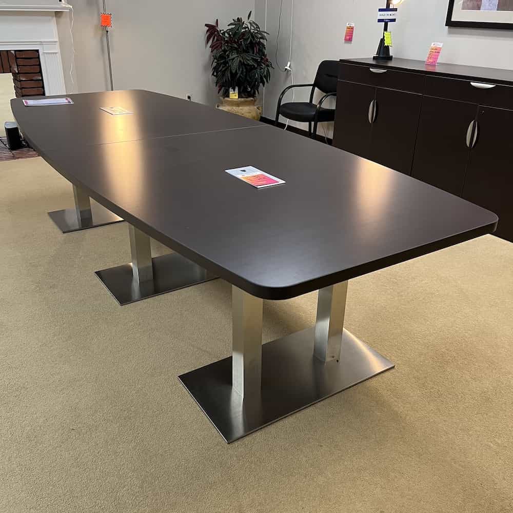 boat shaped conference table with silver legs attached to a silver base