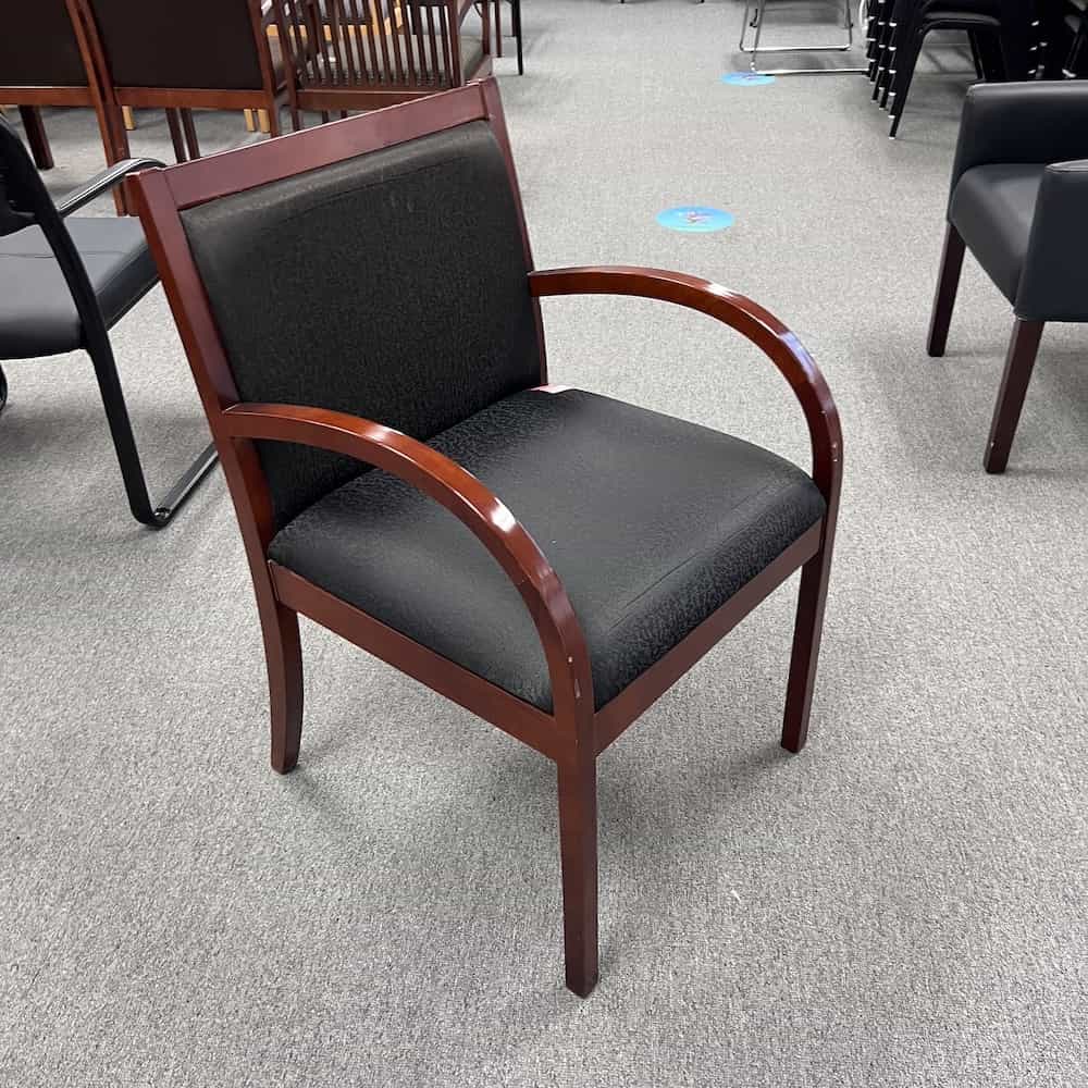 black upholstered guest chair with cherr veneer arms and legs