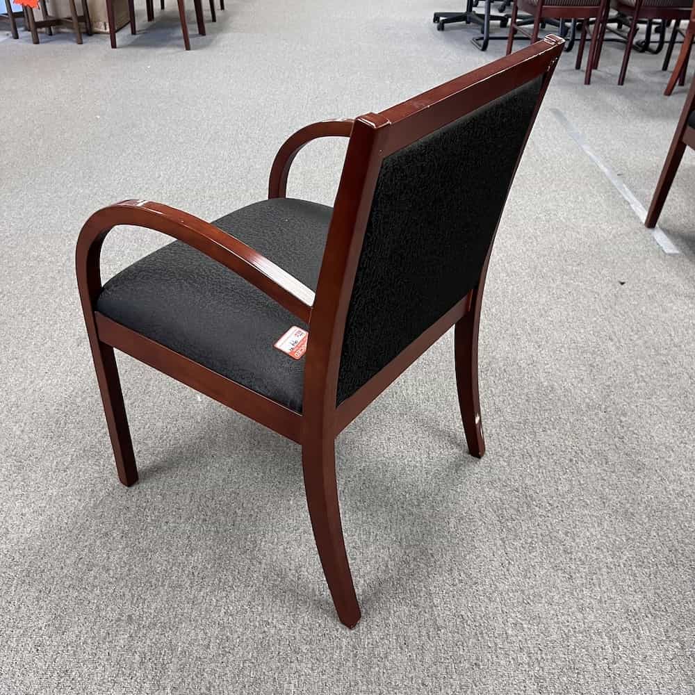 black upholstered guest chair with cherry veneer arms and legs