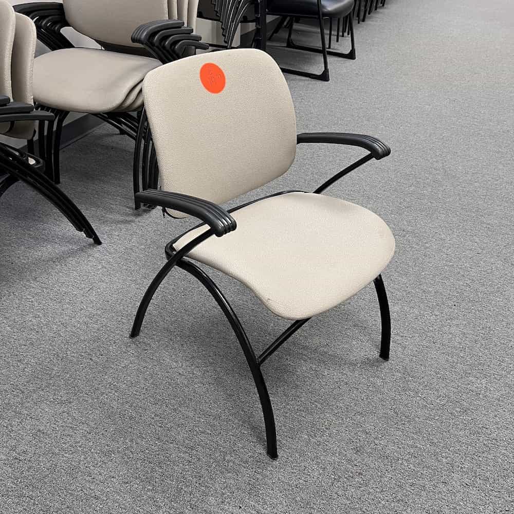white upholstered seat with black arms and legs, stacking chair