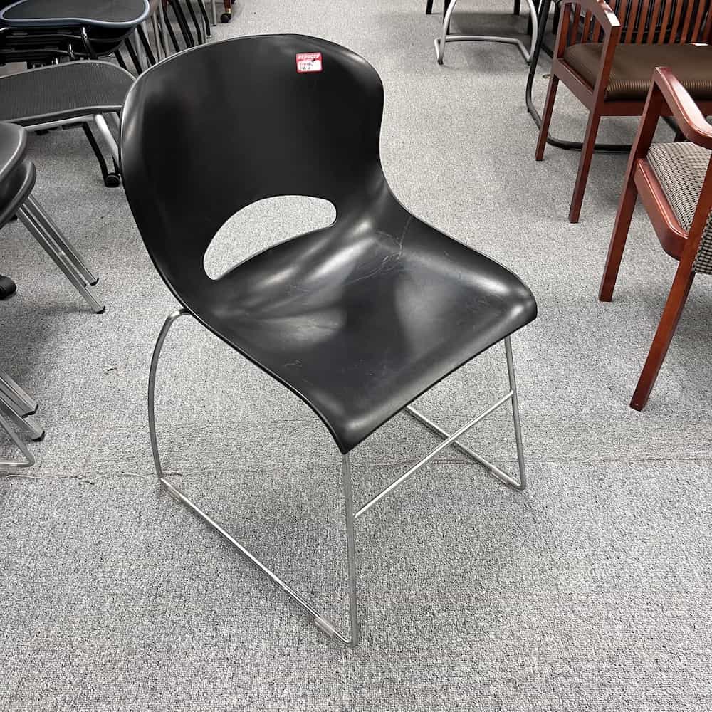 black stacking chair with silver legs, molded seat