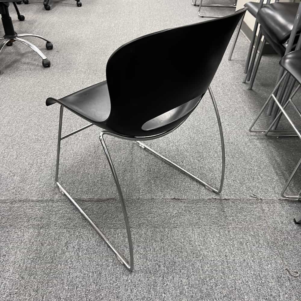 black stacking chair with silver legs, molded seat