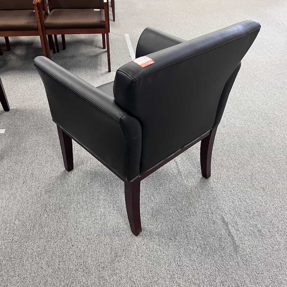 black vinyl guest chair with arms and mahogany legs