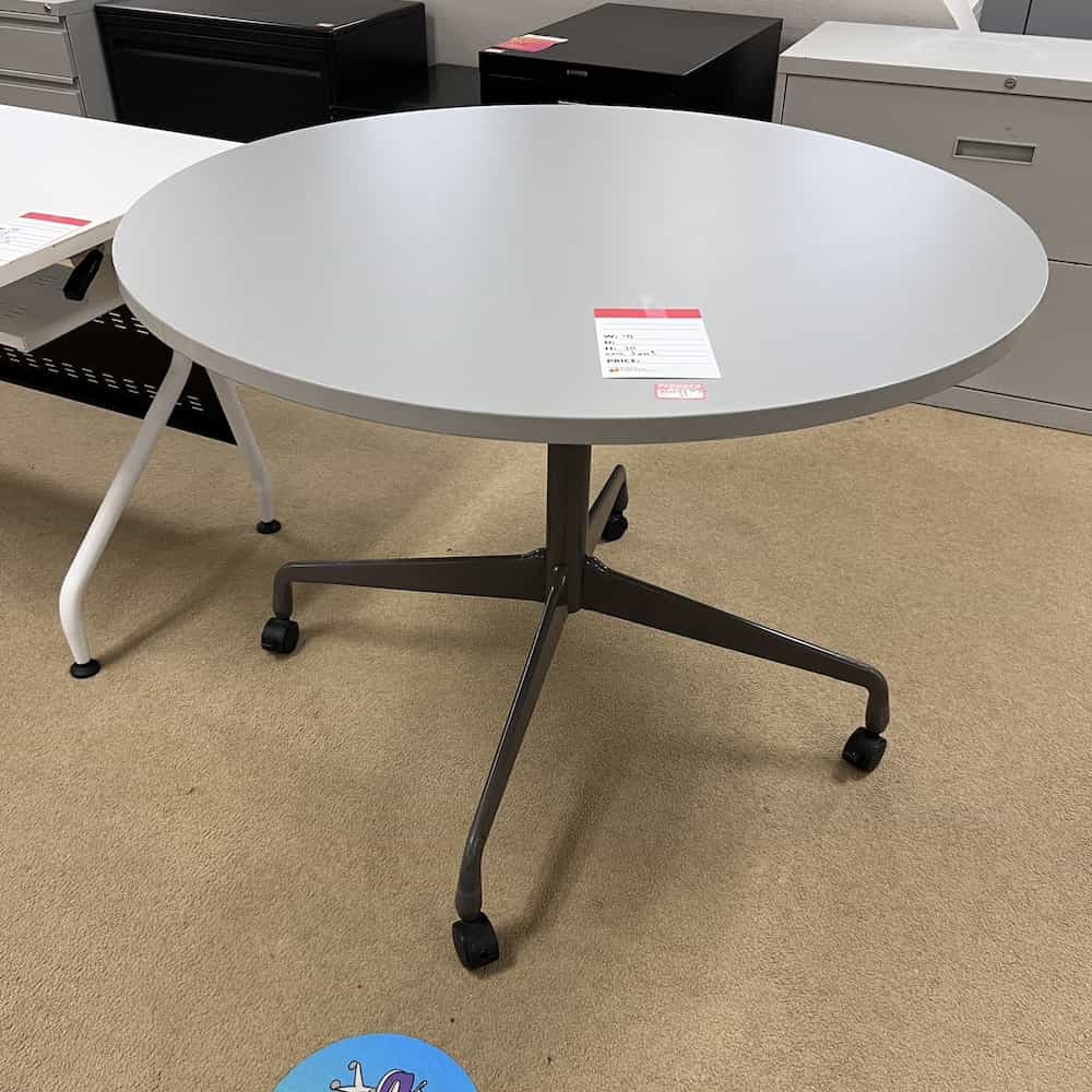 grey laminate round top break room table with grey metal base and wheels