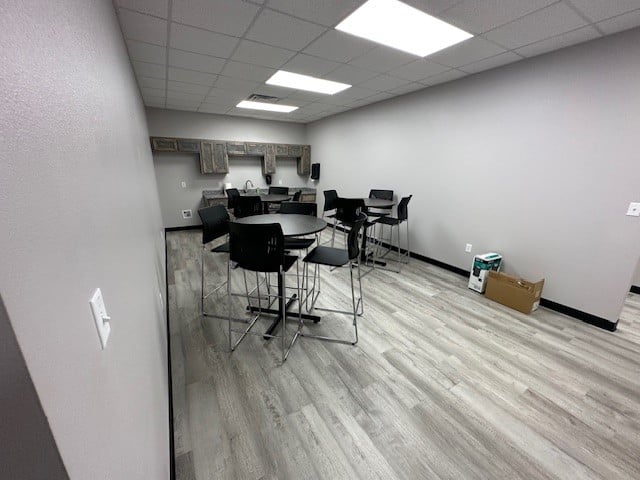 a photo showing brand new office furniture just installed, break room tables, bar height, grey and black