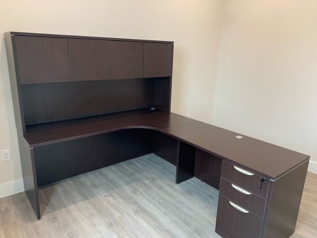 a photo showing brand new office furniture just installed, espresso l-desk with hutch and doors