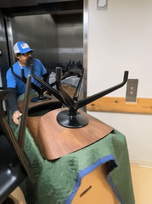 mike in blue moving chairs out of an elevator