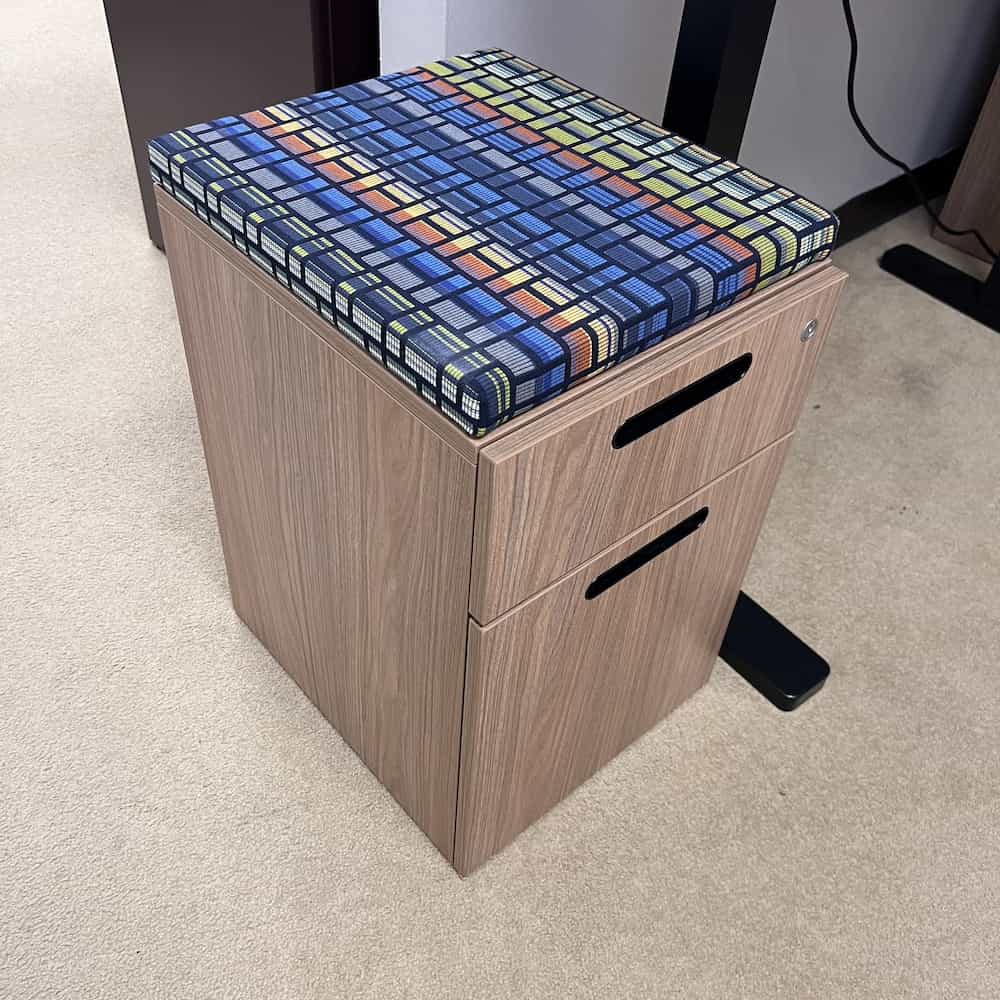 light walnut laminate with black cutout pulls, colorful cushion top, mobile, teknion brand