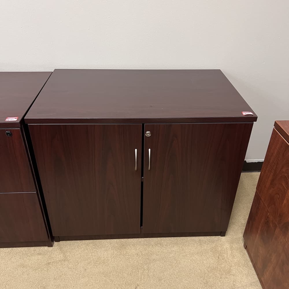 mahogany laminate 2 door storage cabinet with silver pulls, 29" tall, used office furniture