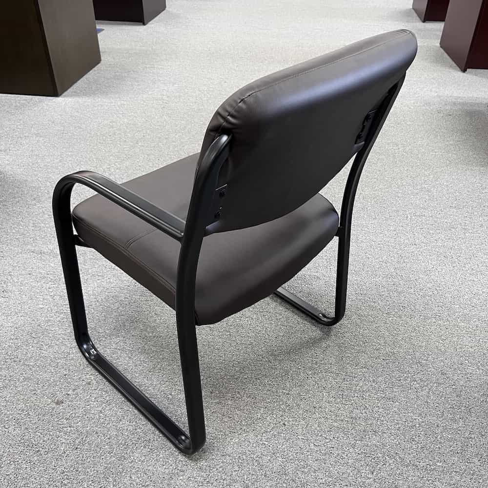 brown vinyl sidekick chair with mid back and black metal legs and arms