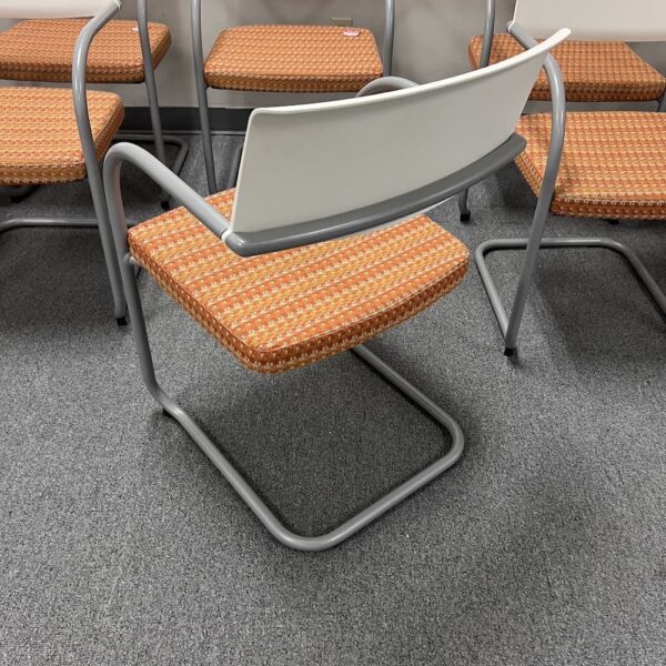 white back and orange upholstered seat knoll moment guest chair with silver arms used furniture office lounge