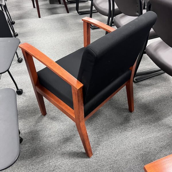 black upholstered guest chair with cherry veneer arms and legs