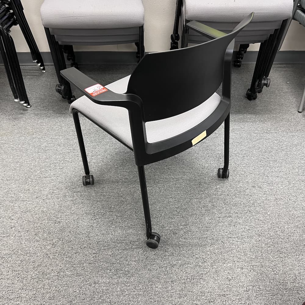 black plastic frame and back, arms, grey upholstered seat. Rolling stacking chair, steelcase move, used office furniture