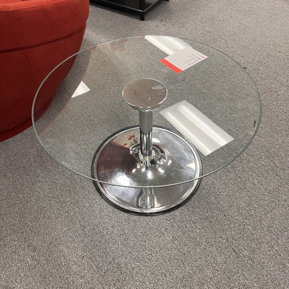Round glass coffee table with silver chrome leg base, used furniture, modern