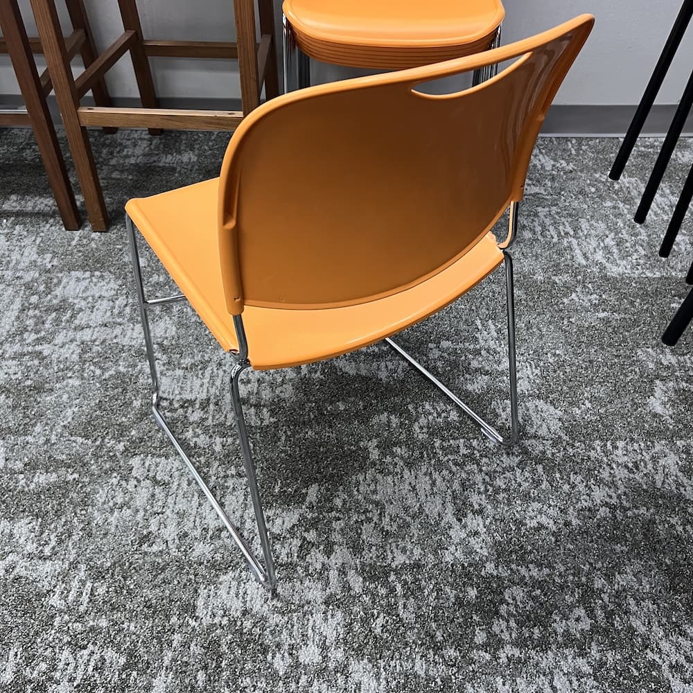 orange stacking plastic chair, used office furniture Lacasse 8400