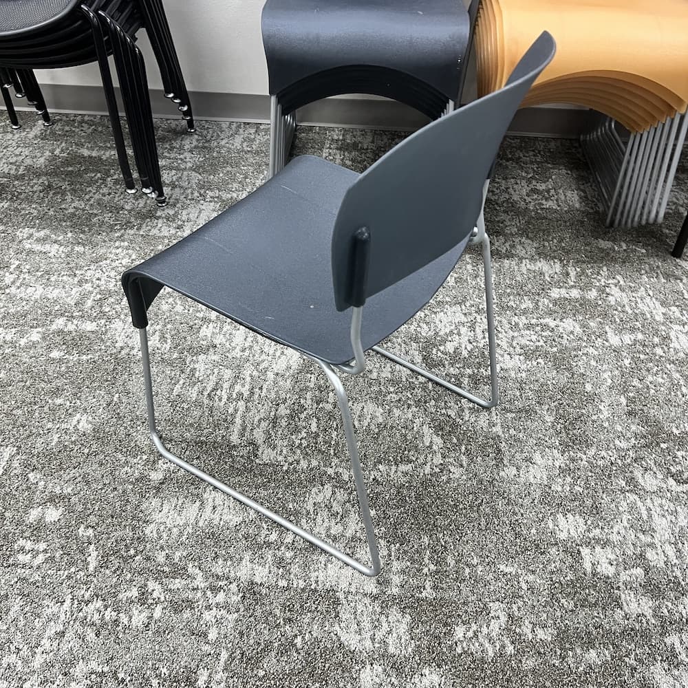 black plastic stacking chair with silver base, used office furniture