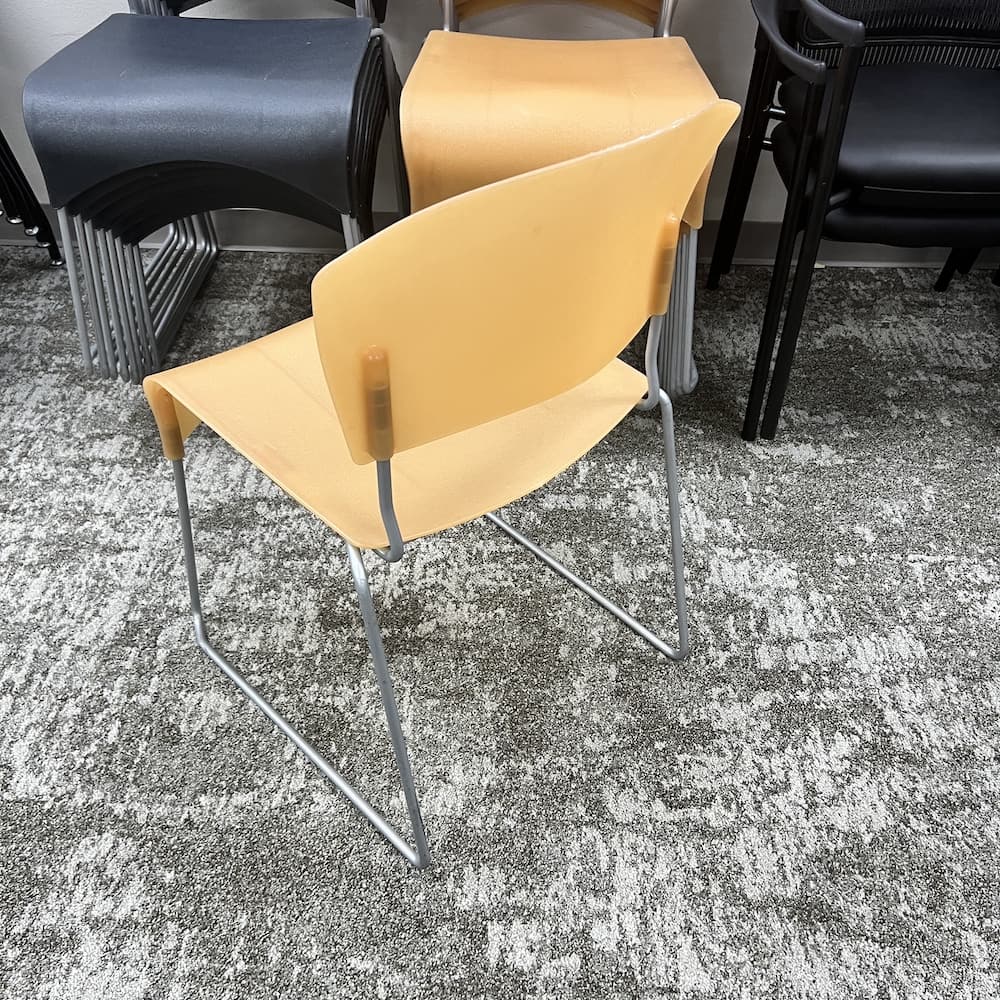 orange plastic stacking chair with silver base, used office furniture