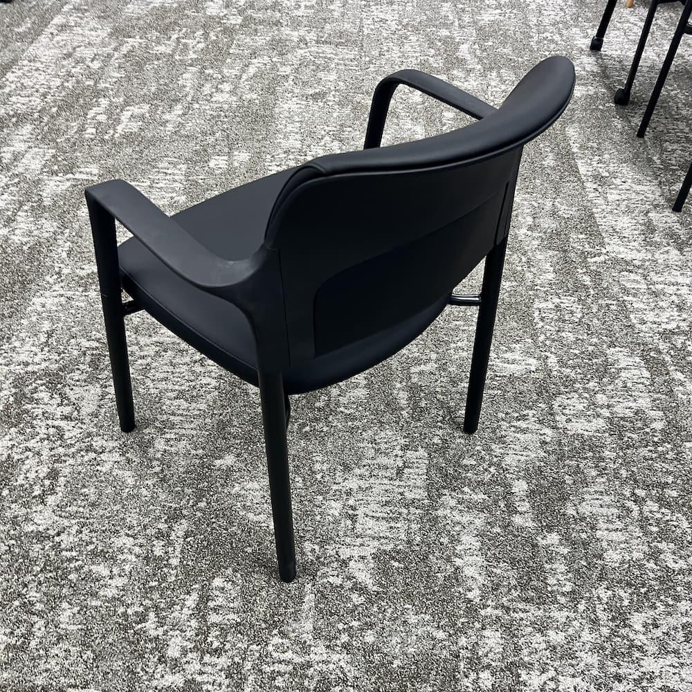 new black vinyl guest chair, stackable, commercial seating, reception seating, break room seating.